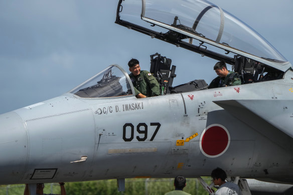 Japanese pilots refuele a F-15 fighter jet at the Tinian airport.