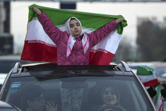 An Iranian girl holds up her country’s flag in Sadeghieh Square. in Tehran.