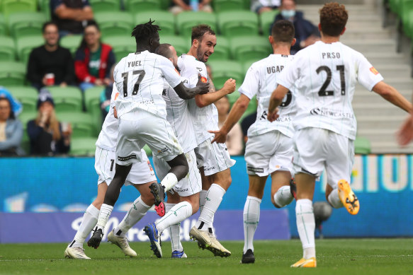 Angus Thurgate (centre) celebrates with Jets teammates after scoring against Melbourne Victory on Sunday.