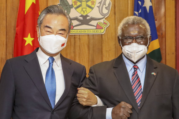 Solomon Islands Prime Minister Manasseh Sogavare (right) locks arms with visiting Chinese Foreign Minister Wang Yi in Honiara, Solomon Islands in 2022.