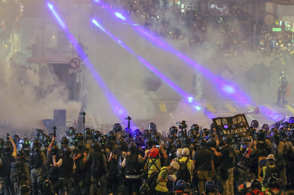 Riot policemen firing tear gas to protesters on a street during the anti-extradition bill protest in Hong Kong in August 2019.