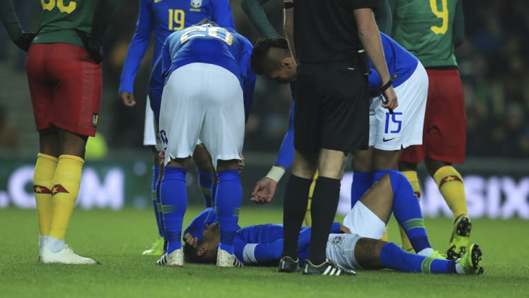 Down and out: Brazil's Neymar lays on the pitch after getting injured during a friendly with Cameroon.