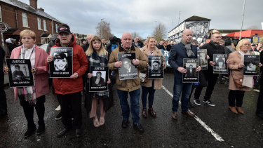 Paul Doherty (centre, holding a picture of Bernard McGuigan, with his niece, Caitlin, to his right) on a protest march for justice for Bloody Sunday victims.