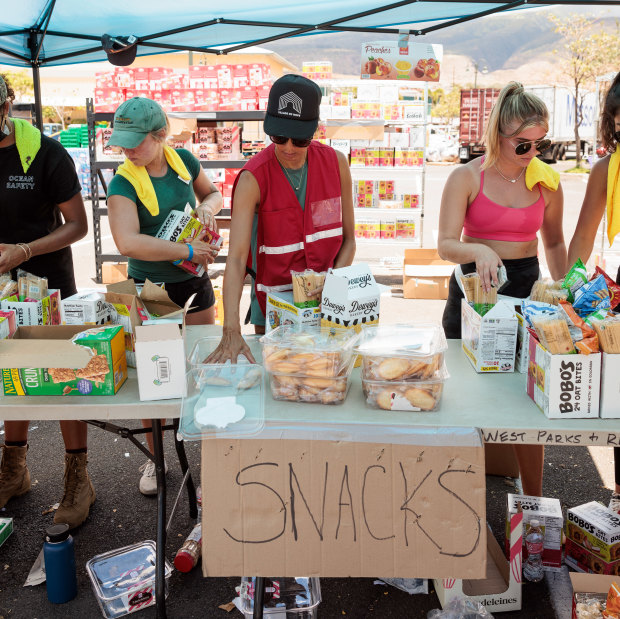 Volunteers sort through donated food items at an emergency aid distribution point for victims of last week’s wildfire in Lahaina, on the Hawaiian island of Maui.