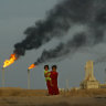 A young girl and her baby sister emerge from the heat and smoke from a petrochemical plant near their family farm, just north of the Iraq-Kuwait border.