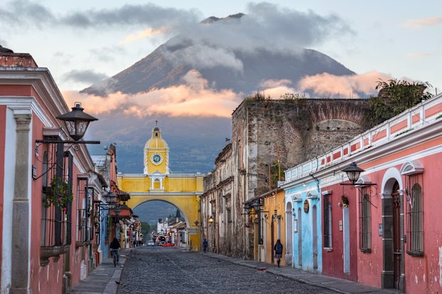 Early morning in Antigua with its old houses, Santa Catalina Arch and volcano beyond.