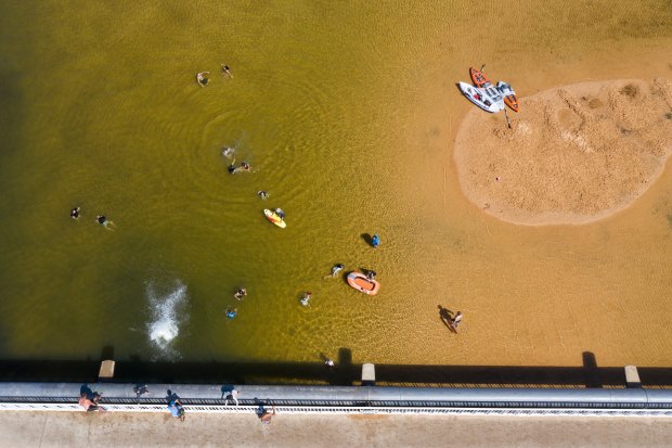 Kids jump from the Narabeen Bridge in Sydney during a heatwave in January 2021.