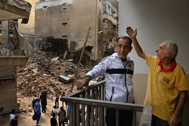  Twins Jamal and Mohammed al-Sheikh on the balcony of their damaged apartment.