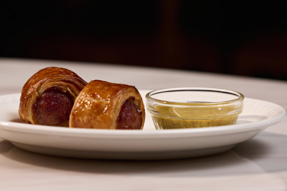 Pigs in blankets, house-made pork sausages swaddled in rich pastry and served with ale mustard.