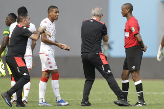 Tunisia’s head coach Mondher Kebaier, centre, gestures to referee Janny Sikazwe, claiming that he ended the match early.