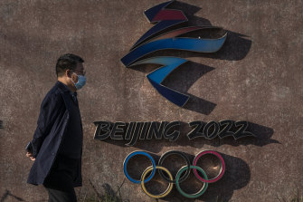 A visitor walks by the logo for the Beijing 2022 Winter Olympics at Shougang.
