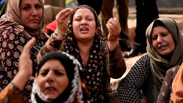 The female relatives of Syrian Democratic Forces soldier Adnan Hassan during his funeral at the Martyr’s cemetery in Bir Kavira. 