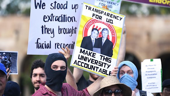 Students hold placards demanding transparency from the University of Queensland. 