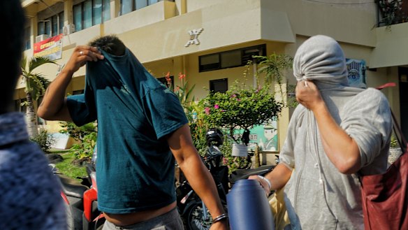 Australian nightclub promoters William Cabantog (blue shirt) and David Van Iersel (grey shirt) are transferred between cells at Denpasar police station. 