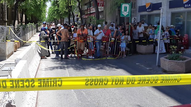 People are prevented from entering a security area after an explosion in Tunis.