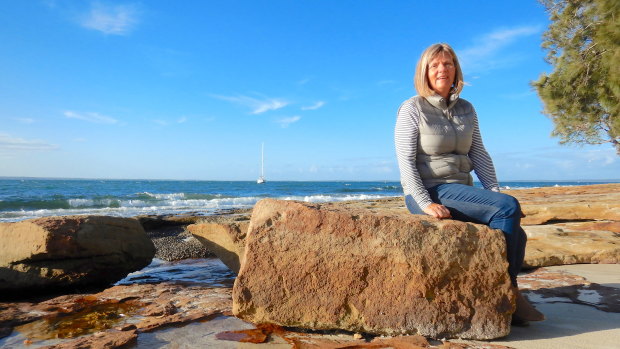 Jenny Robertson sits on an old sandstone block, a remnant of the South Huskisson wharf at the end of the Wool Road.