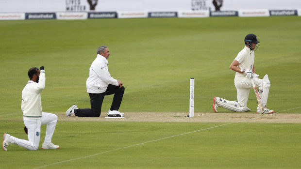 England and West Indian players and the umpires take the knee at the start of the first Test this year.