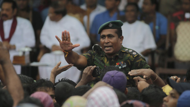 A Sri Lankan police officer tries to control supporters of Sri Lankan President Maithripala Sirisena at a Colombo rally last week.