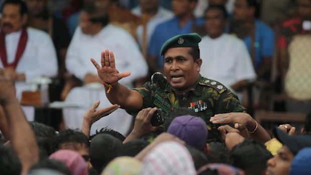 A Sri Lankan police officer tries to control supporters of Sri Lankan President Maithripala Sirisena at a Colombo rally last week.