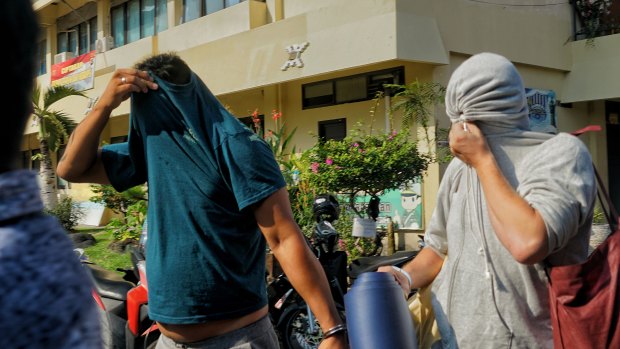 Australian nightclub promoters William Cabantog (blue shirt) and David Van Iersel (grey shirt) are transferred between cells at Denpasar police station. 