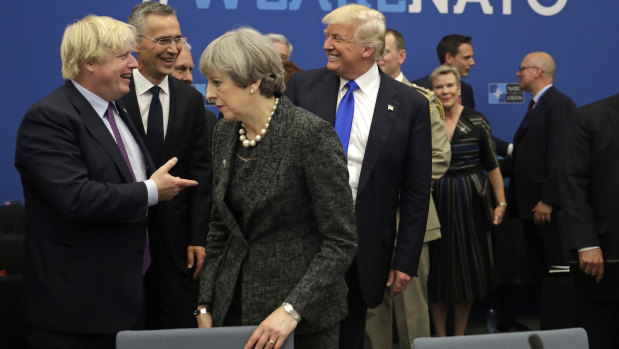 President Donald Trump jokes with British Foreign Minister Boris Johnson as British Prime Minister Theresa May walks past during a working dinner meeting at the NATO headquarters in May, 2017.