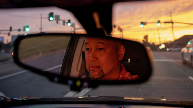 Robby Perez, who says in a lawsuit he was sexually abused by a priest when he was 11 years old in Guam, sits at a traffic light during sunset in New Orleans, where he now lives.