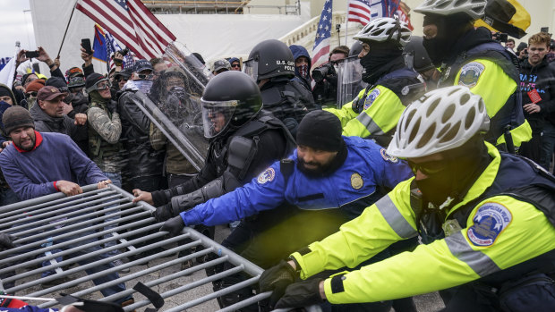 Trump supporters try to break through a police barrier. 