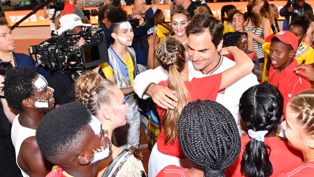 Roger Federer hugs young fans after defeating Rafael Nadal at Cape Town Stadium.