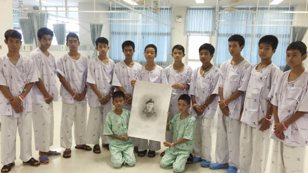 The rescued boys hold a portrait of former Thai Navy SEAL Saman Gunan, who died during the rescue effort.