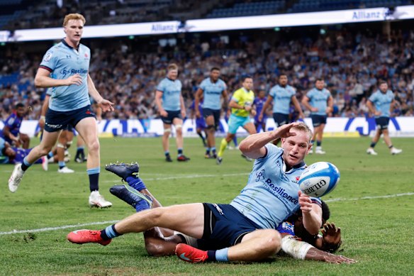 Max Jorgensen of the Waratahs defends a diving attempt from Taniela Rakuro of Fijian Drua during the round two Super Rugby match between NSW Waratahs and Fijian Drua at Allianz Stadium