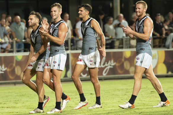 Port Adelaide players celebrate their one-point win.