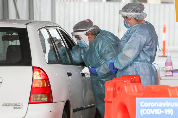 Nurses work at a drive-through COVID-19 testing site.