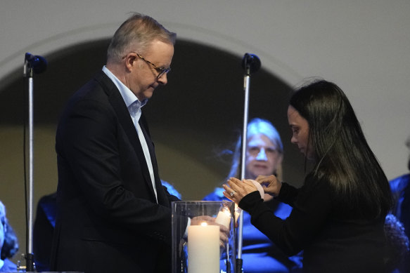 Prime Minister Anthony Albanese lights a candle during the vigil.