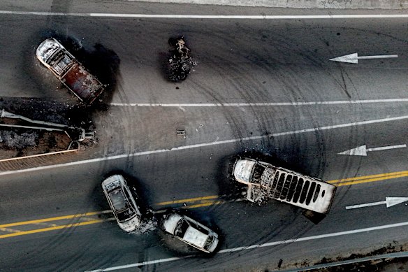 An overhead view shows burnt cars and trucks slewed across a road by cartel gangsters near Acatlan de Juarez.