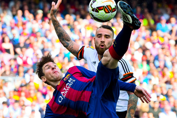 Lionel Messi tussles with Valencia's Nicolas Otamendi during a 2015 La Liga clash.
