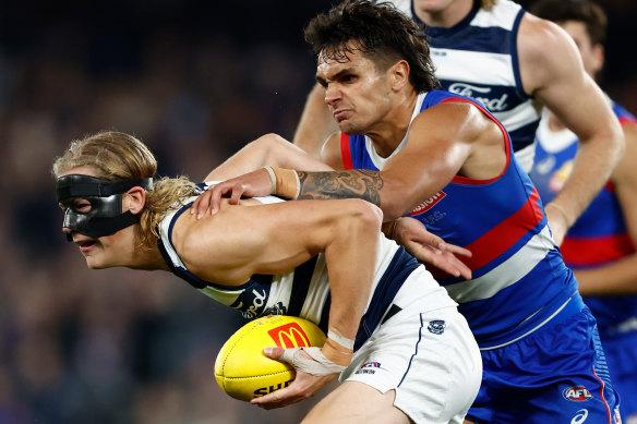 Geelong’s Sam De Koning is tackled by Jamarra Ugle-Hagan of the Bulldogs.