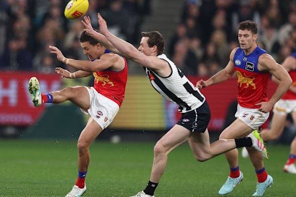Brisbane’s Hugh McCluggage gets his kick away despite Ned Long’s attempt to smother.