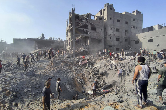 Палестинцы осматривают повреждения зданий, разрушенных в результате авиаударов Израиля по лагерю беженцев Джабалия.