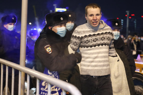 Police officers detain a man at Moscow's Vnukovo airport ahead of the scheduled arrival of Alexei Navalny.