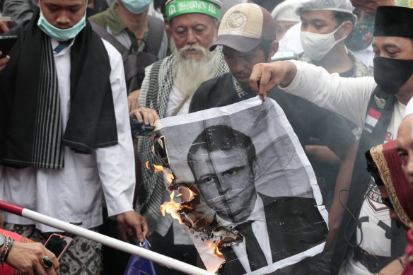 Muslim men burn a portrait of French President Emmanuel Macron during a protest outside the France embassy in Jakarta, Indonesia, on November 2.