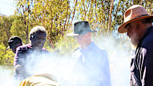 Federal Court Justice Stephen Burley (centre) visited Yindjibarndi country before handing down his native title ruling during his at Bangkangarra via a smoking ceremony, by (L-R) Angus Mack, Stanley Warrie and Michael Woodley.