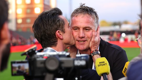 Coach Phil Parkinson is on the receiving end of an appreciative kiss from owner Rob Mac after Wrexham secured promotion to the Championship.