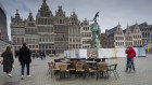 People walk by chairs and tables of an empty terrace in the historical centre of Antwerp, Belgium, which has just announced the closure of all bars and cafés for four weeks.