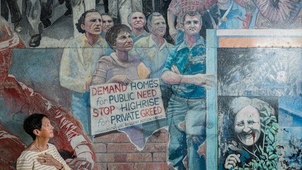 Judy Mundey looks up at a mural that shows her late husband Jack Mundey - in the upper right with a loudspeaker -  a leader of the Builders Labourer Federation and the green ban movement which saved the ’Loo for working-class people and defeated a proposal for highrise.