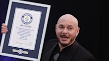 Pitbull, is presented with a Guinness World Record certificate for the largest gathering of people wearing bald cap ahead of his performance at at BST Hyde Park in London
