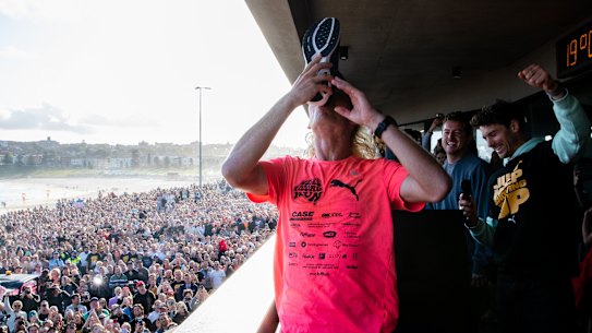Nedd Brockmann celebrates in front of a large crowd of fans at Bondi Beach after his run from Perth.
