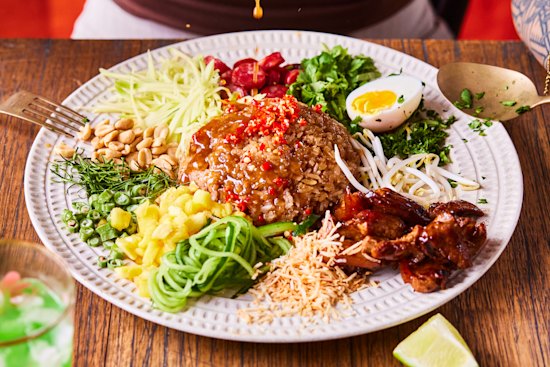 Toss the khao yum (Thai rice salad) to ensure maximum flavour in every bite.