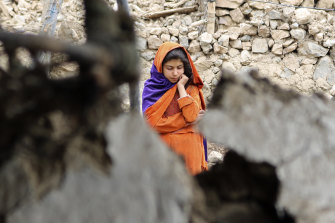 An Afghan girl stands near a house that was damaged by an earthquake in the Spera District of the southwestern part of Khost province.