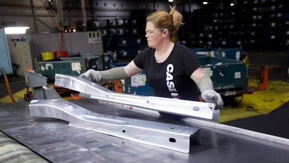 United Auto Workers line worker Crystal McIntyre unloads parts from a stamping machine at the General Motors Pontiac Metal Centre in Michigan.