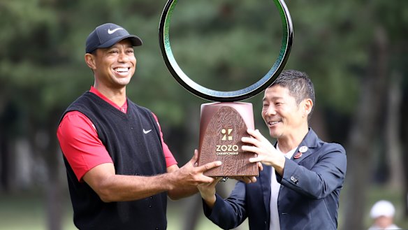 Golfer Tiger Woods receives the trophy from the Zozo founder Yusaku Maezawa at the Zozo Championship in Inzai, Chiba, Japan, last year.